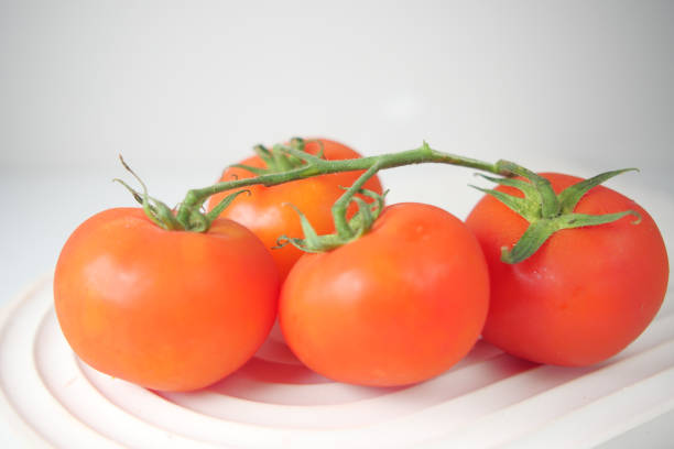 group of ripe red tomatoes on table .