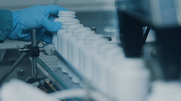 istock 4K conveyor with moving empty white plastic tubes on the production line and filling with capsules. Automatic machine in the factory. Modern High-Tech Pharmacology Factory. Close Up, DOF 1614841683