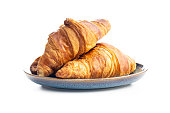 Fresh butter croissant on plate isolated on white background.