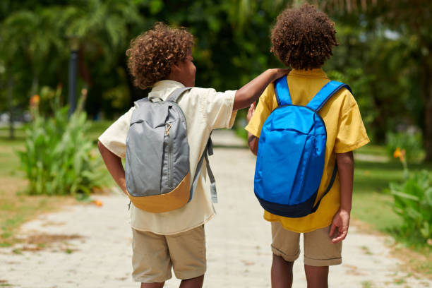 istock Kids with Backpacks in Park 1614873282