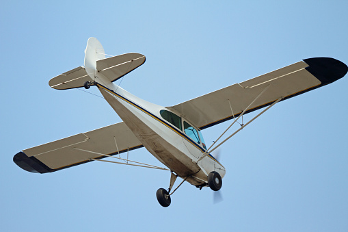 Small plane on blue cloudy sky background