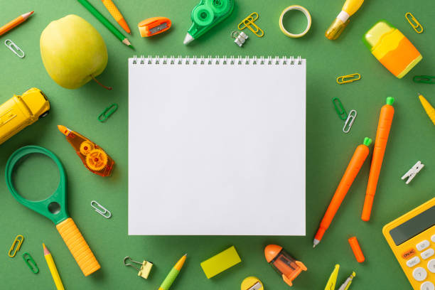 istock Unleash your creativity and learn. Discover top view array of amusing stationery like carrot-shaped pens, pencils, album, cute bus toy and more, all on green board backdrop with space for ad placement 1614888698