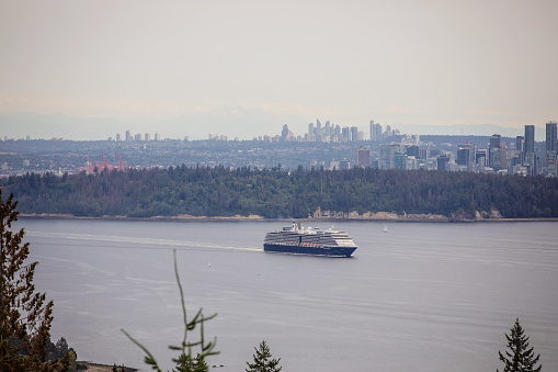 North Vancouver, Canada - August 6, 2023. A cruise ship passes by at the Cyprus Pop-up Village viewpoint in North Vancouver.
