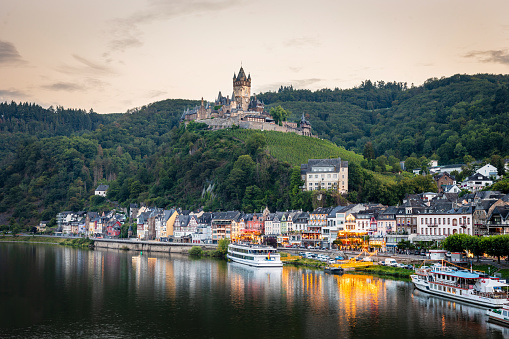 Fussen, Germany - August 7, 2015: Beautiful view of world-famous Neuschwanstein Castle, the nineteenth-century Romanesque Revival palace built for King Ludwig II on a rugged cliff, with scenic mountain landscape near Fussen, southwest Bavaria, Germany.