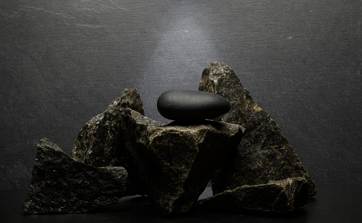 black stones on dark gray background for product presentation podium background.