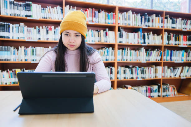 istock College space: Front view of Young Female University Student Studying with her Tablet at the Library 1614934091