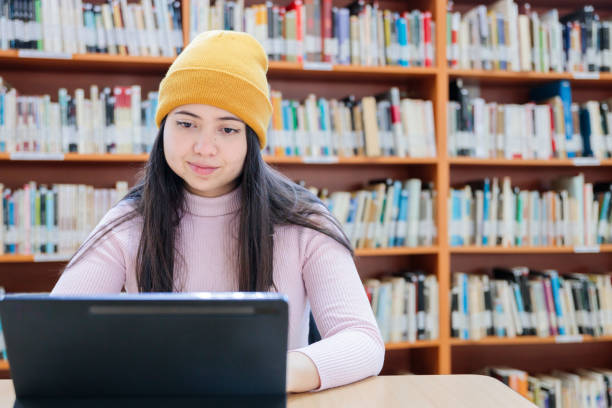 istock College space: Front view of Young Female University Student Studying with her Tablet at the Library 1614937238