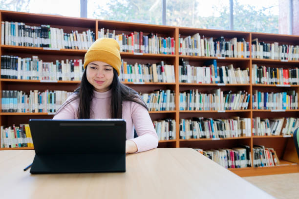 istock Focused College Life: Young Female University Student Engaged in Tablet Study at the Library 1614937239