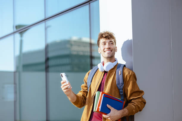 istock Young male student using smart phone on the street 1614982843