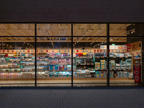 A look through a window in a empty supermarket at night time. Copenhagen, Denmark - August 14, 2023.