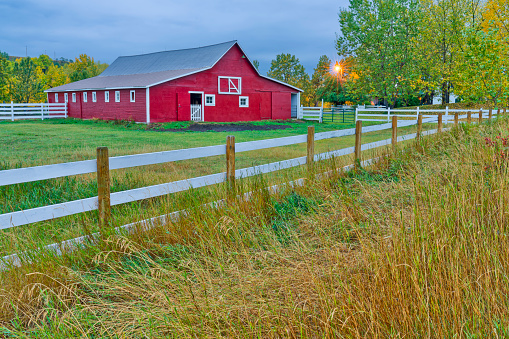 Bright red barn on a farm at dusk in rural Alberta Canada