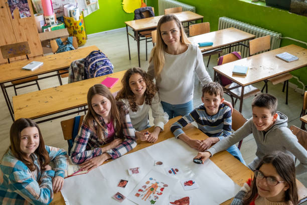 istock teenagers with a teacher at school 1615052712