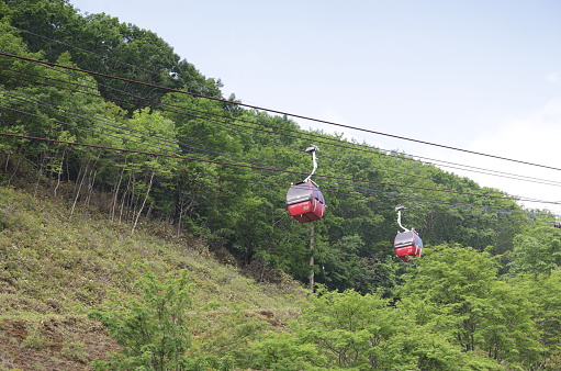 Noboribetsu Onsen, Japan - June 7, 2023: Overhead cable cars travel the ropeway in the volcanic landscape of Shikotsu-Toya National Park.