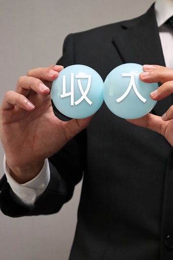 Photo of a person holding a ball with income written on it