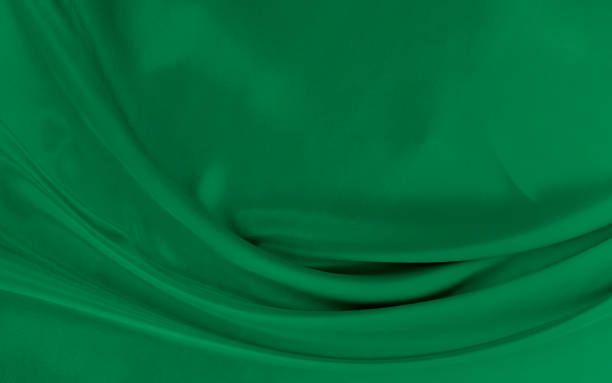 istock Black green satin dark fabric texture luxurious shiny that is abstract silk cloth background with patterns soft waves blur beautiful. 1615149576