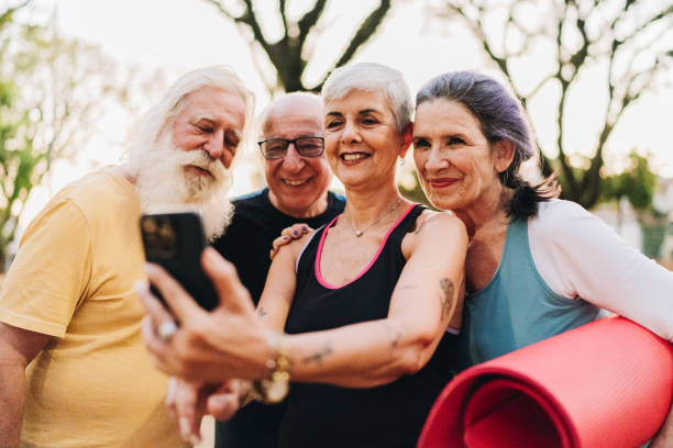 istock Senior friends taking a selfie using mobile phone after exercise class in a public park 1615150107