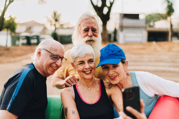 istock Senior friends taking a selfie using mobile phone after exercise class in a public park 1615150108