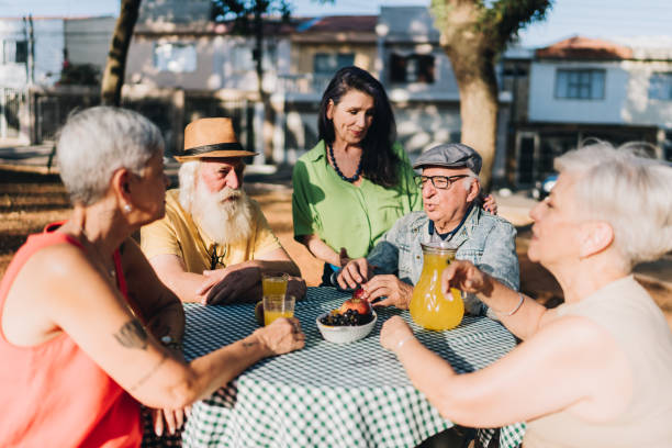 istock Senior friends talking during picnic in a public park 1615162467
