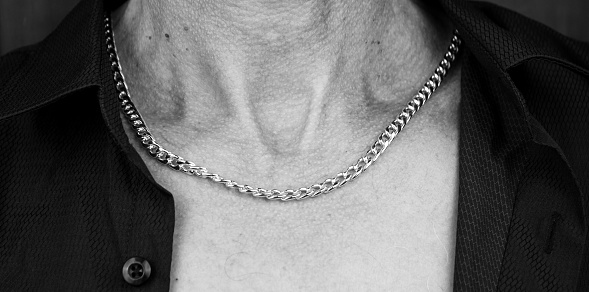 Man in a shirt with a chain around his neck.Men's silver chain.Men's decoration,long chain.