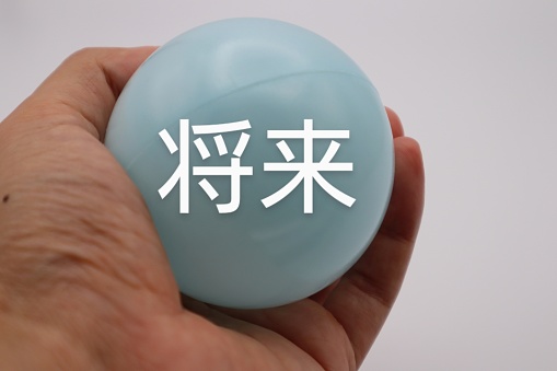 Photo of a person holding a ball with the future written on it