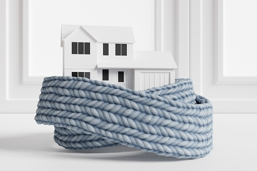 White house wrapped by a blue scarf with windows as background. 3D illustration of the concept of saving energy by insulating houses