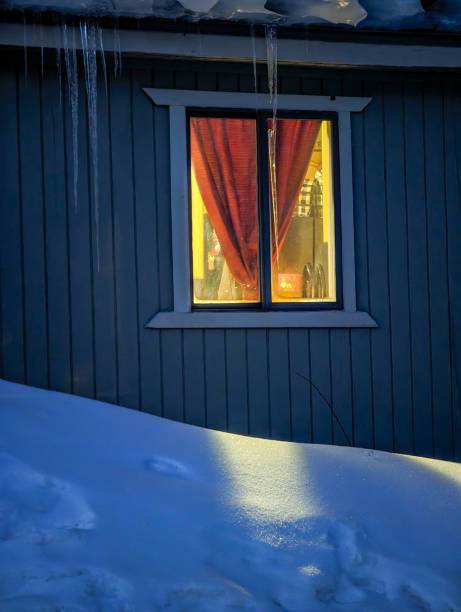 istock mountain hut and window light in the snow in the evening 1615232982