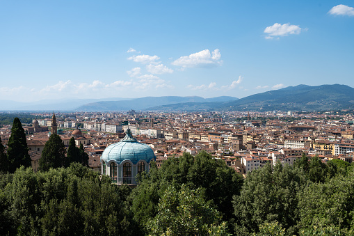View of western part of Florence, Italy. We can see many points of interests, foliages from trees and mountains in the distance.