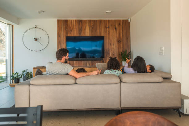 familia multiétnica disfrutando de una película en el sofá - apartment television family couple fotografías e imágenes de stock