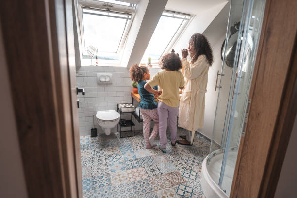 istock Mother and Daughters Preparing for the Day in Bright Bathroom 1615333328