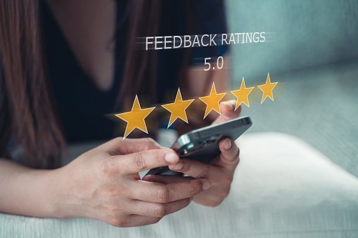 Customer review good rating concept, hand using smartphone with popup o five star icon on visual screen for positive customer feedback, testimonial and testimony, user comment and feedback for review.