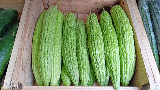 green bitter groud vegetables in a wooden crate box for sale in the market