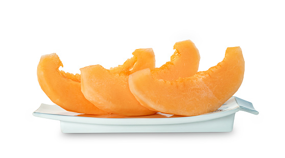 Orange cantaloupe melon fruit sliced on dish isolated on white background ,include clipping path