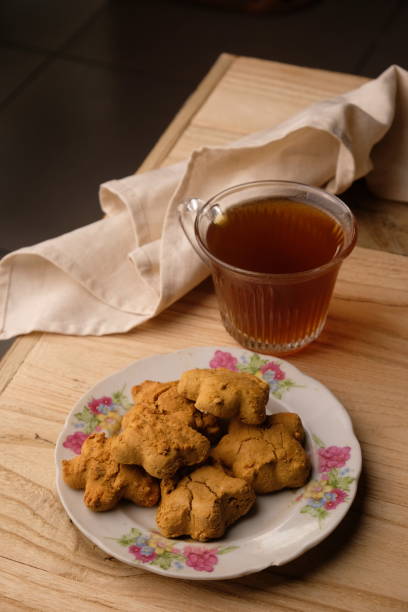 istock Kue Jahe Jadul, Star-shaped gingerbread cookies on a cooling rack. Pekalongan's typical ginger cake. Indonesian food. Cookies Jahe. A cup of tea. 1615445440