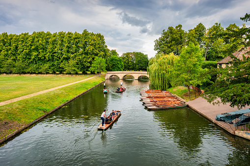 People take part in a punting tour in Cambridge, England, UK on a cloudy day.