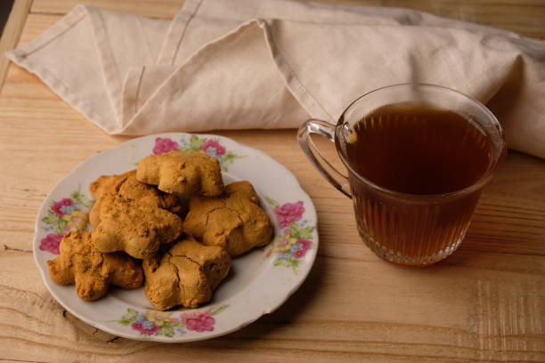 istock Kue Jahe Jadul, Star-shaped gingerbread cookies on a cooling rack. Pekalongan's typical ginger cake. Indonesian food. Cookies Jahe. A cup of tea. 1615449051