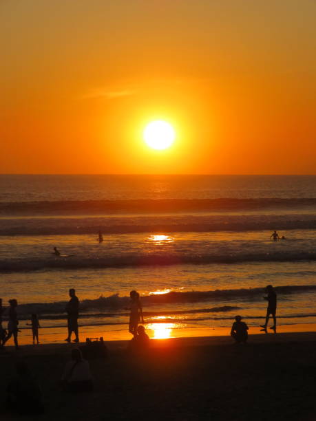 istock Silhouette of people on beach at sunset 1615479253