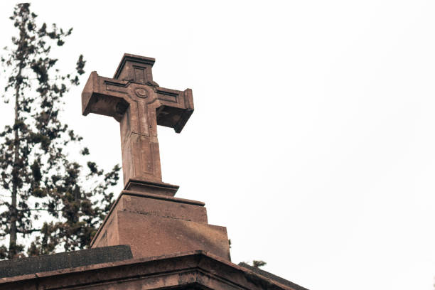Silhouette of tomb crosses in a Christian cemetery at sunset.