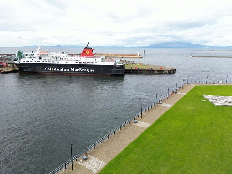 Ardrossan, United Kingdom – August 11, 2023: A large ferry boat traversing a harbor on a cloudy day in Ardrossan Marina, Scotland