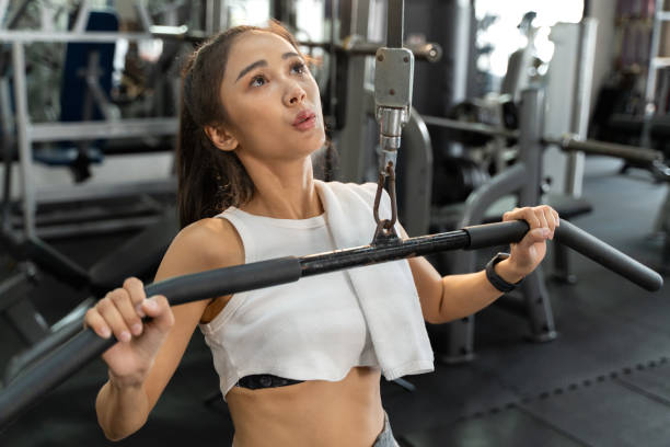 istock Young attractive woman using a workout equipment to work on her upper body workout at a fitness gym 1615532938