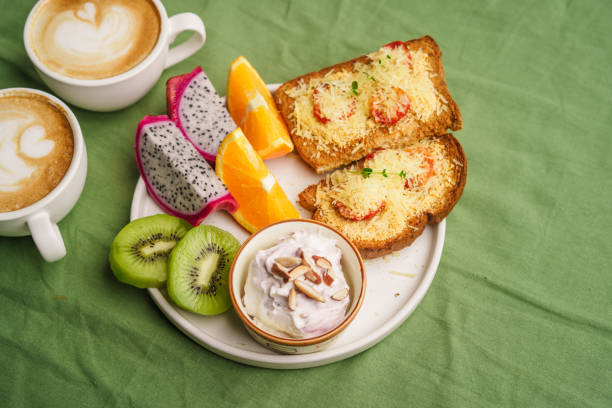 istock Breakfast toast with cheese and tomatoes, fruit, yogurt. 1615533990