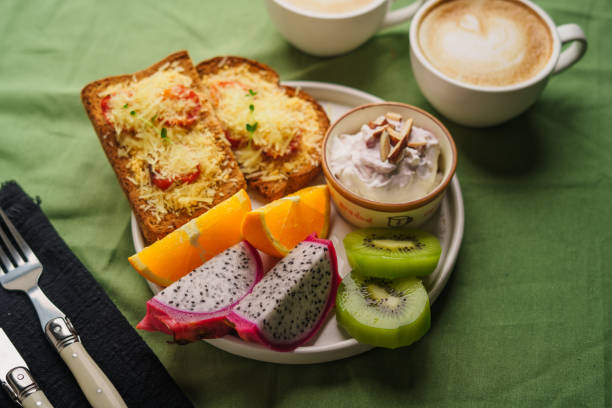 istock Breakfast toast with cheese and tomatoes, fruit, yogurt. 1615534513