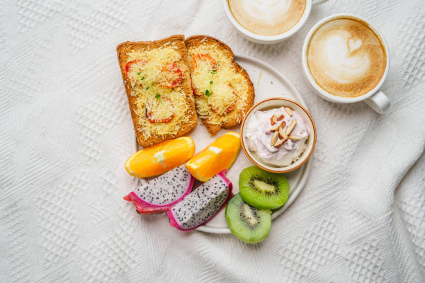 Breakfast toast with cheese and tomatoes, fruit, yogurt, coffee.
