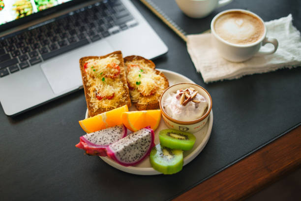 Breakfast toast with cheese and tomatoes, fruit, yogurt, coffee.