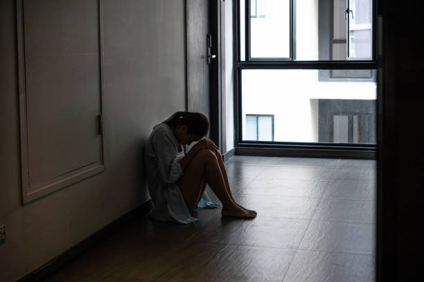 istock Stressed young Asian woman suffering on depression sitting alone. Sad, unhappy, sad, violence concept. Copy space 1615597421