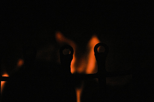 Flame is burning in dark fireplace