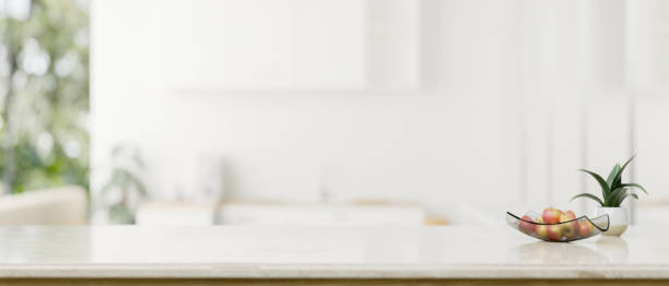 istock Copy space on a white tabletop over a blurred modern white kitchen in the background. 1615624296
