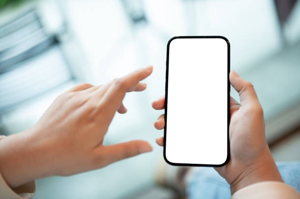 istock A woman holding a smartphone with a white screen mockup over a blurred cafe in background. 1615625357