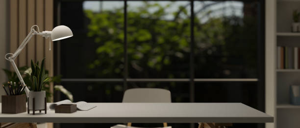 istock A white table with copy space, a table lamp, book, and potted plants in a modern room. 1615626941