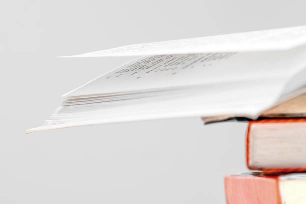 istock Stack of books in library, one of them open on top, multicolored book spines. Education concept. 1615634912