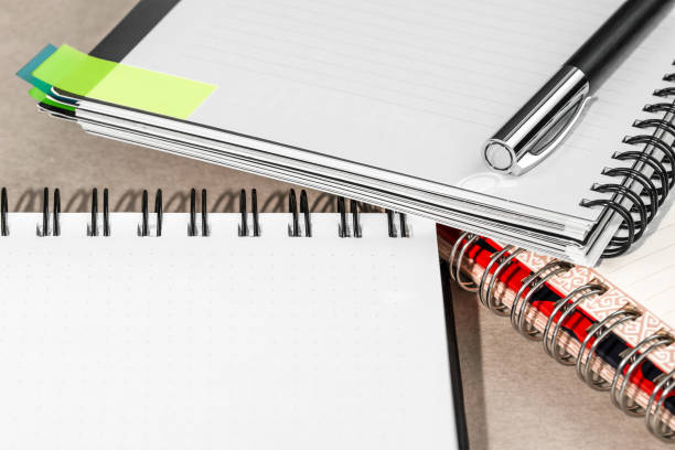 istock Several spiral notebooks and one pen lie on the office table, place for text. 1615640582